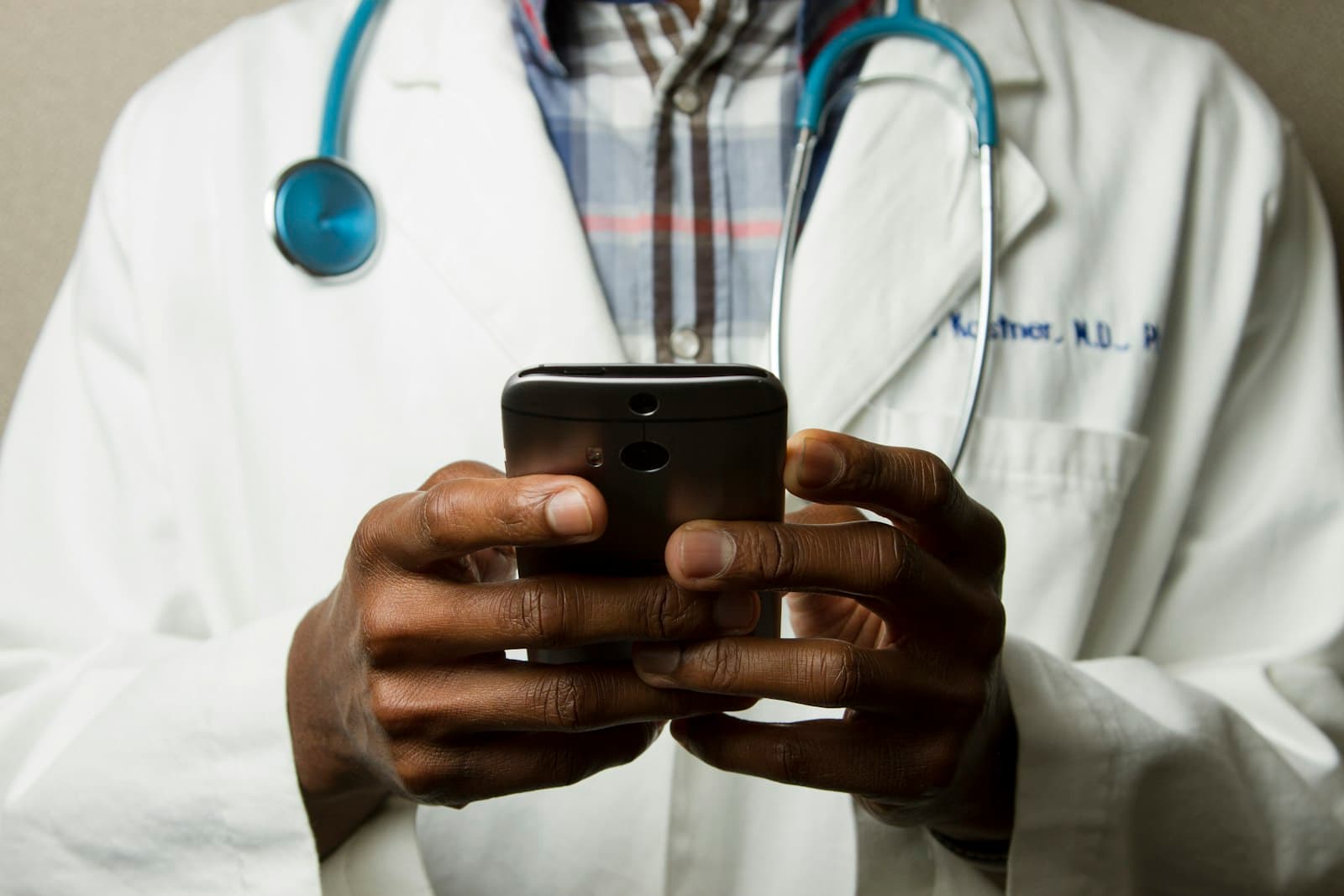 Two clinicians reviewing a tablet together in a bright clinic.