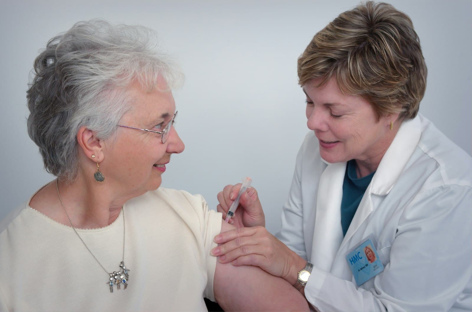 A clinician with a stethoscope beside a patient.