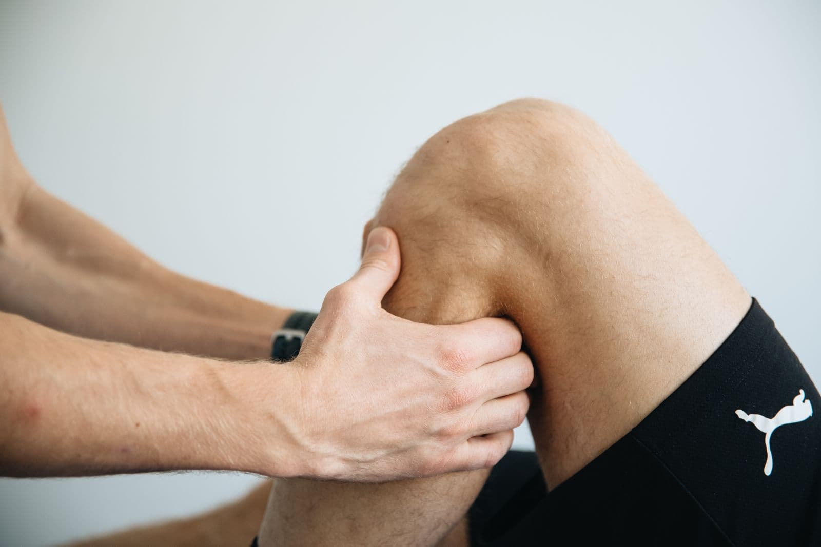 A physiotherapist works on a patient's knee.